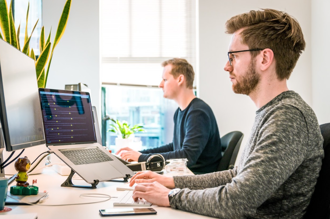 Twee mannen werken achter computer