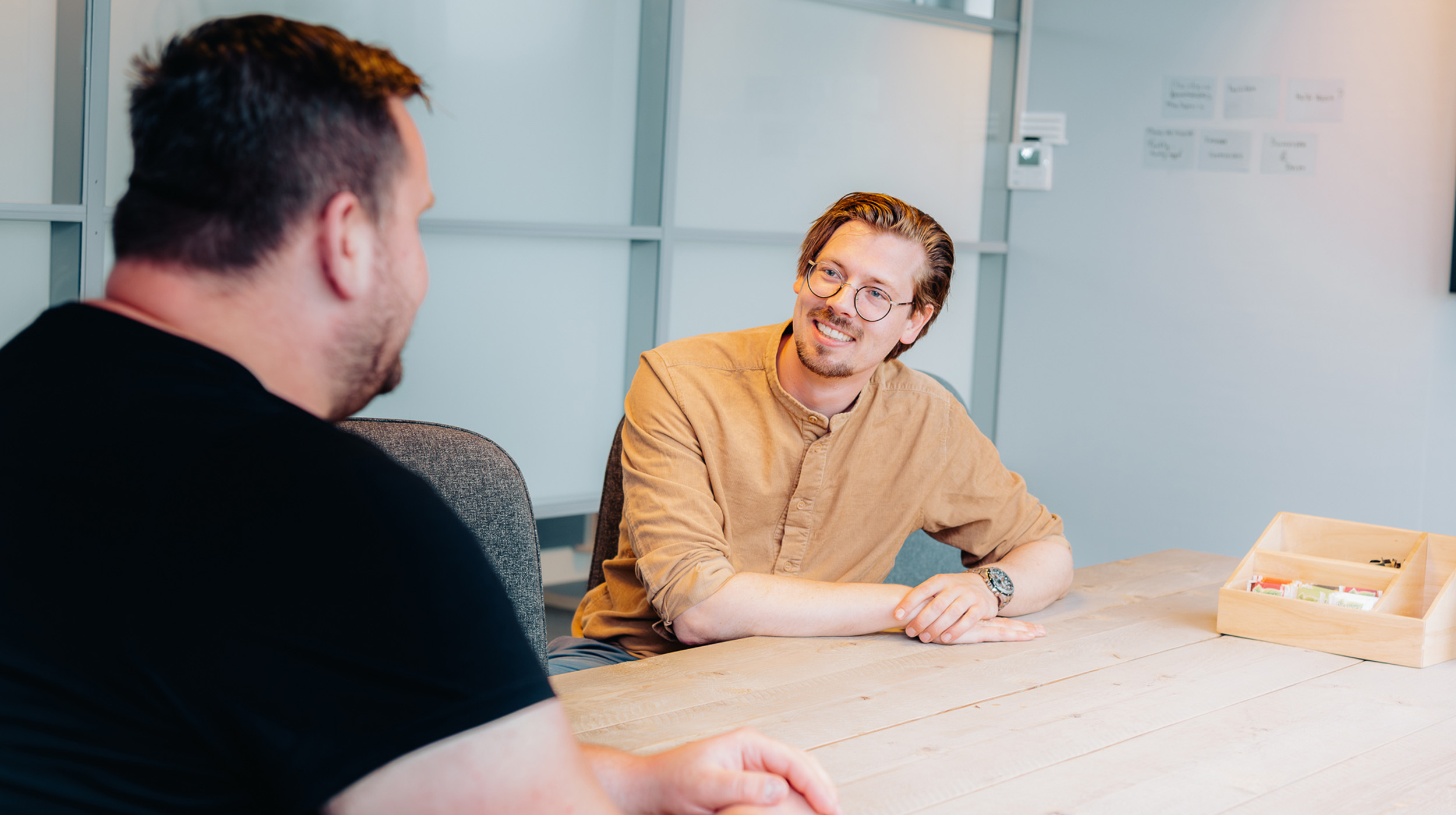Deelnemer en zorgbegeleider in gesprek.